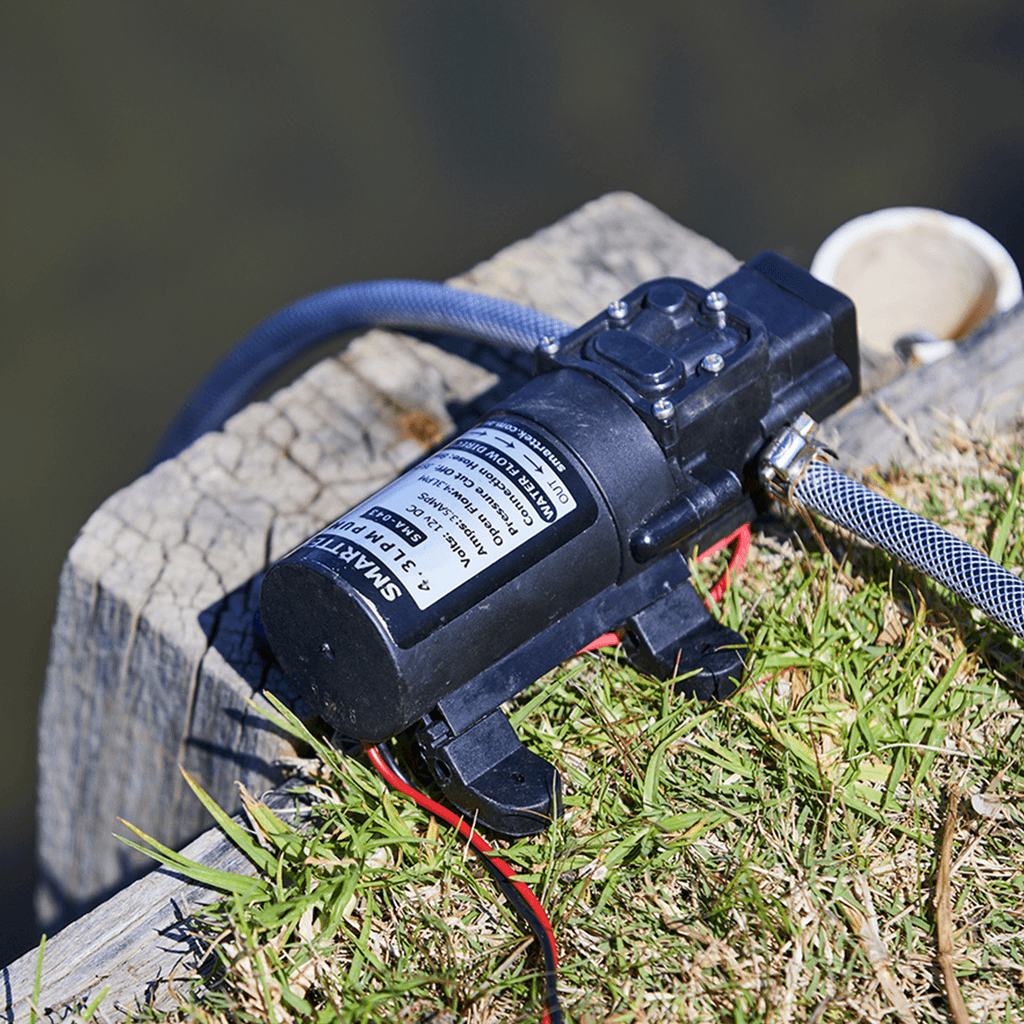 Smarttek 4.3LPM water pump set up outdoors and connected to a water source for use with a Smarttek hot water system.