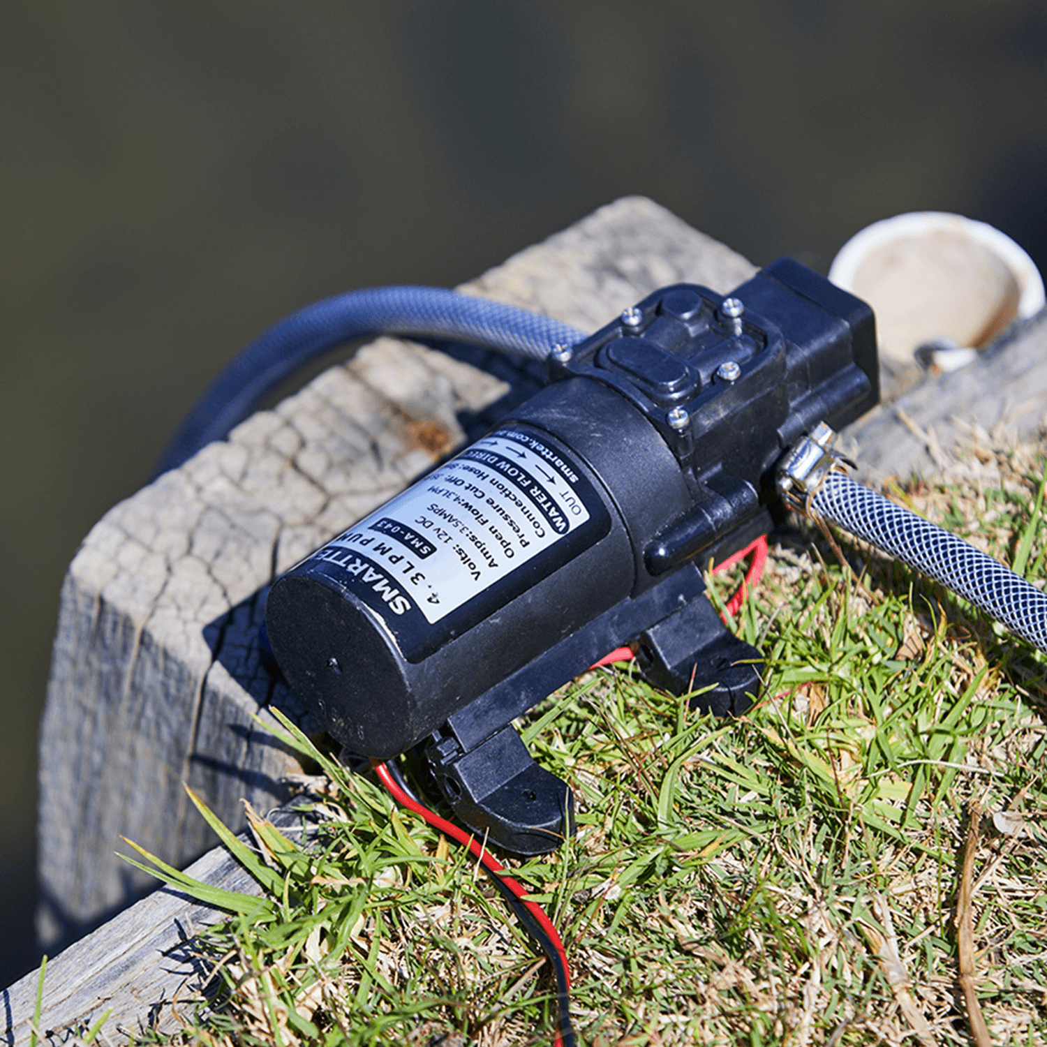 Smarttek 4.3LPM water pump set up outdoors and connected to a water source for use with a Smarttek hot water system.